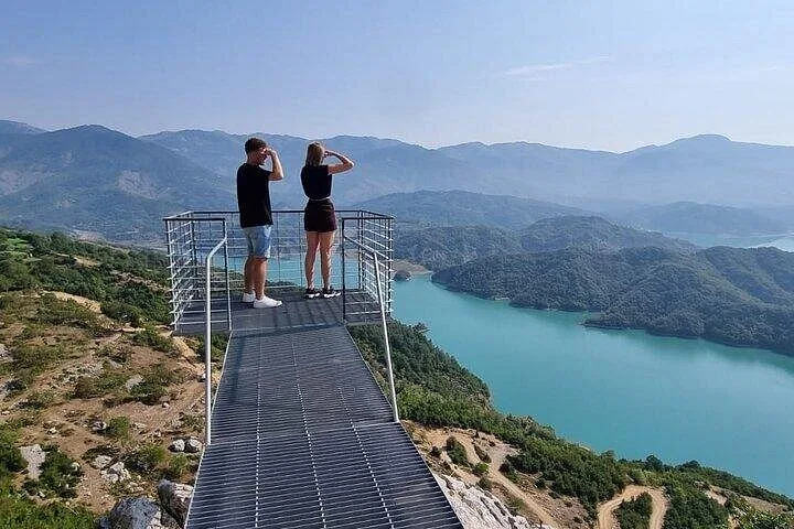 Ein Paar steht auf einer Aussichtsplattform aus Metall mit Blick auf den Bovilla-See.